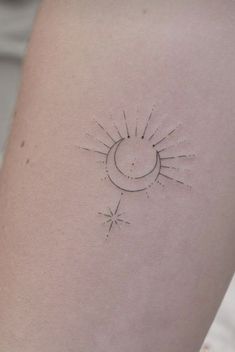 a small sun and moon tattoo on the back of a woman's left arm