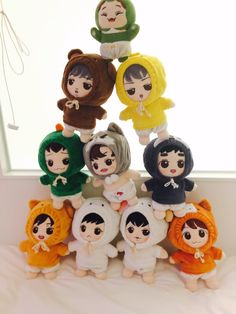 a group of small dolls sitting on top of each other in front of a window