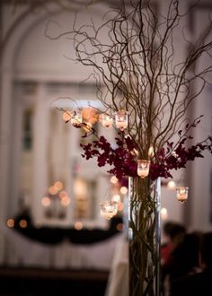 a vase filled with flowers and candles on top of a table