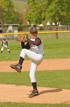 a baseball player pitching a ball on top of a pitchers mound during a game stock photography