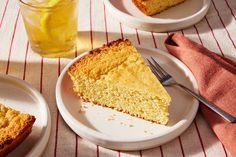 a piece of cake on a plate next to a glass of lemonade and a fork