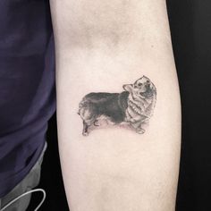 a small dog tattoo on the left arm