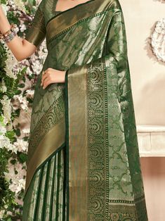 Celebrate your upcoming festivals, weddings, and occasions with the stunning "fascinating green zari weaving silk mehendi wear saree with blouse" from Ethnic Plus. This beautiful green saree is designed with intricate zari weaving work, adding a touch of elegance and sophistication to your ethnic look. The set includes a similar color silk blouse with zari weaving work, perfectly complementing the saree for a complete ensemble.
The saree is 5.50 meters in length, providing ample fabric to drape Green Pre-draped Saree With Meenakari For Puja, Festive Green Pre-draped Saree With Zari Weaving, Green Semi-stitched Pre-draped Saree With Meenakari, Green Dola Silk Pre-draped Saree For Diwali, Green Pre-draped Saree With Zari Weaving For Diwali, Green Bollywood Pre-draped Saree With Meenakari, Transitional Green Dola Silk Choli, Green Paithani Silk Pre-draped Saree With Self Design, Green Pre-draped Saree With Self Design For Diwali