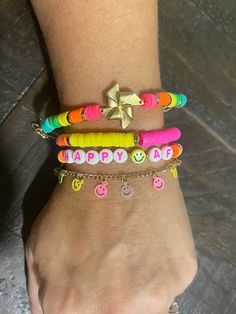 "~Winnie~ This four piece bracelet set is super colorful and super fun PLUS you can customize one of the bracelets for personalization. The set includes: - the matte gold, windmill bracelet with colorful, rubber, heishi cut beads in vibrant colors with gold toned, heishi spacers. This bracelet is size adjustable from 5.5\"-7\" long. - the rubber, heishi bead bracelet with vibrant pink, green, white, yellow and orange sections with gold toned, heishi spacers separating the colors. All are strung on clear, stretch cord. This bracelet is roughly 7\" around, unstretched.  - the \"HappyAF\" bracelet. This bracelet spells out \"HappyAF\" with a yellow smiley face bead separating the words. The rest of the bracelet is made up of rubber, heishi cut beads in various vibrant colors with the tie knot Heishi Bead Bracelet, Rainbow Braids, Yellow Smiley Face, Star And Moon Necklace, Silk Bag, Necklace Extender, Neon Rainbow, Rainbow Bracelet, Heart Pendant Gold