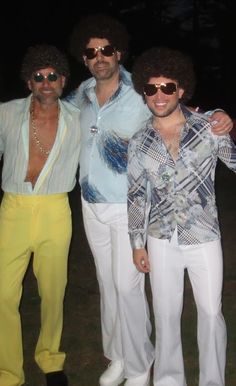 three men in white pants and blue shirts posing for the camera