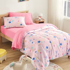 a child's bedroom with pink and blue bedding, stars on the comforter