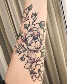 a black and white rose tattoo on the arm