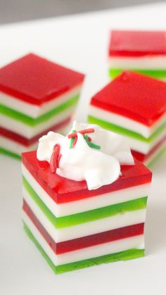 three pieces of cake sitting on top of a white table with red, green and white frosting