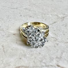 CLEARANCE - 40% OFF! A magnificent and fine vintage diamond cluster cocktail ring crafted in 14 karat yellow and white gold. Circa 1970. It is set with 19 round diamonds weighing approximately 1.35 CTTW.The stones are approximately G-H color, SI clarity. Stamped 14K. Weighs 8.5 grams. Size 6.75 US / N UK. > Ring sizing not included.This ring can be sized to fit most fingers.If you need to size this ring, please contact us before placing the order.Sized rings are final sale. Our minimum sizing fe Timeless Diamond Cluster Ring With 17 Jewels, Heirloom Yellow Gold Cluster Wedding Ring, Classic Vvs Clarity Cluster Ring, White Cluster Ring Stamped 14k, Cluster Diamond Ring With Prong Setting, Anniversary Diamond White Cluster Ring, Heirloom Style Brilliant Cut Cluster Ring, Gold Collectible Cluster Ring, Heirloom Brilliant Cut Cluster Ring