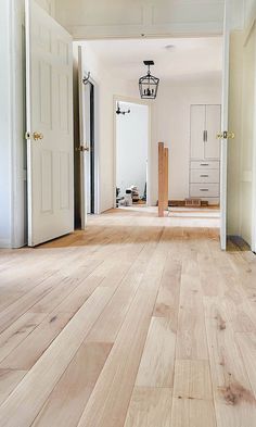 an empty room with wooden floors and white doors