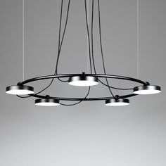 a modern chandelier with five lights hanging from it's center and four circular lamps on each end