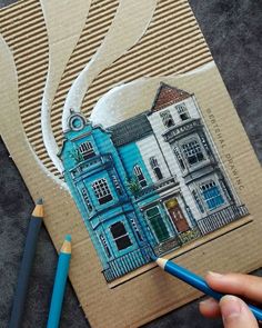 a drawing of a blue house on top of a piece of cardboard