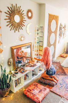 a woman sitting on the floor in front of a mirror