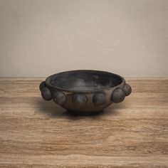 a metal bowl sitting on top of a wooden table