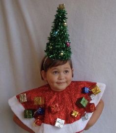 a little boy wearing a christmas tree costume