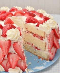 a cake with white frosting and sliced strawberries on the top is ready to be eaten