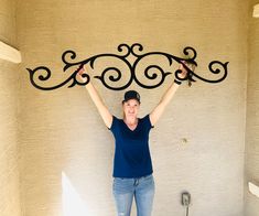 a woman holding up a wrought iron shelf