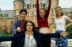 four people posing for a photo in front of a castle