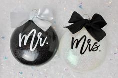 two black and white ornaments with the word mr and mrs painted on one ornament