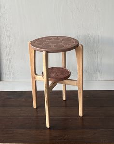 a small wooden table sitting on top of a hard wood floor next to a white wall