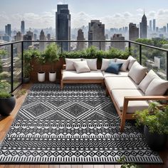 an outdoor living area with couches and potted plants in front of the city skyline