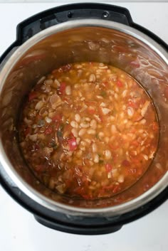 a pot filled with beans and vegetables on top of a stove