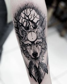 a black and white tattoo with a wolf on it's arm