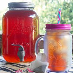 two mason jars filled with liquid sitting on top of a table