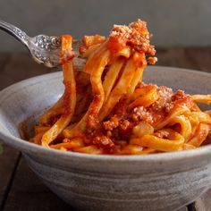 a bowl filled with pasta and meat sauce