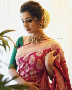 a woman wearing a pink and green sari