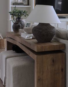 a table with a lamp on top of it next to a couch