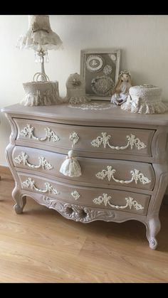 an antique dresser with white paint and ornate carvings on the drawers is shown in this image