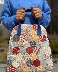 the woman is holding her handbag in front of her face