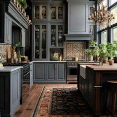 a kitchen filled with lots of gray cabinets and counter top space next to a window