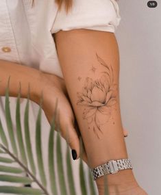 a woman's arm with a flower tattoo on the left side of her arm