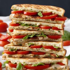 a stack of grilled sandwiches with tomatoes and lettuce