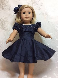 the doll is wearing a blue dress with pearls on it's head and hands