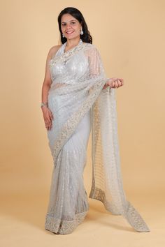 Indulge in luxury with our net designer saree in a stunning blue hue. Adorned with delicate thread embroidery and sparkling sequins, this saree exudes sophistication and elegance. Perfect for any occasion, its lightweight net fabric drapes beautifully for an effortlessly glamorous look. Elevate your style with this exclusive piece. Net designer saree with thread embroidery and sequin work - blue color Saree comes with a blouse piece. Fall and pico done. Fully stitched blouse shown in pictures is optional and can be purchased seperately from our blouses and croptops section. For saree video please connect with us on whatsapp @469-937-0606 Ready to be shipped in USA from San Diego, California. All pictures are original pictures. Colors may slightly vary due to pic resolution. Diwali Silver Pre-draped Saree With Mirror Work, Silver Pre-draped Saree With Mirror Work For Diwali, Silver Georgette Pre-draped Saree For Wedding, Silver Semi-stitched Pre-draped Saree For Designer Wear, Silver Pre-draped Saree With Resham Embroidery For Reception, Silver Pre-draped Saree With Mirror Work, Festive Silver Pre-draped Saree With Resham Embroidery, Designer Silver Blouse Piece With Resham Embroidery, Silver Saree For Reception