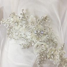 a bridal sash with flowers and pearls on it