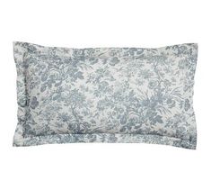 a blue and white floral pillow on a white background