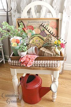 a red watering can sitting on top of a wooden table