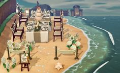 a table set up on the beach for an ocean themed dinner party with white and green flowers