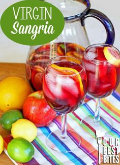 two glasses filled with sangria sitting on top of a table next to lemons