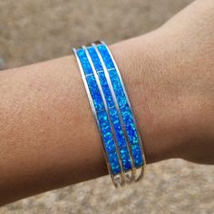 This Is A Beautiful Zuni Tribe Sterling Silver Inlay Cuff Bracelet That Features Multiple Manmade Blue Opal Stones. Handmade And Stamped By The Zuni Tribe Artisan Jamie Johnson. This Would Be A Great Addition To Any Southwest Us Jewelry Enthusiast's Collection. Wrist Inside Circumference Is 6 Inches (With Gap) Cuff Bracelet Measures .5 Inch Wide Gap Distance Is 1.125 Inches Weight: 13 Grams Blue Cuff Bracelet Bangle For Formal Occasions, Blue Bangle Cuff Bracelet For Formal Occasions, Formal Blue Bangle Cuff Bracelet, Sterling Silver Blue Oyster Bracelet, Adjustable Blue Oyster Bracelet Jewelry, Adjustable Blue Sterling Silver Bangle Bracelet, Elegant Blue Sterling Silver Cuff Bracelet, Handmade Blue Sterling Silver Bangle Bracelet, Blue Sterling Silver Adjustable Bracelet For Formal Occasions