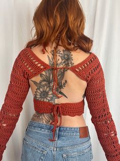 the back of a woman's top with crochet and flowers on it