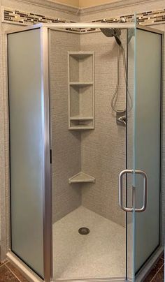 a walk in shower sitting inside of a bathroom next to a tiled floor and walls