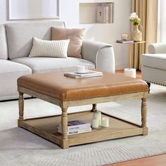 a living room filled with furniture and a coffee table on top of a rug in front of a window