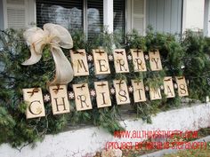 christmas decorations on the windowsill with wooden blocks spelling merry christmas and bows hanging from them