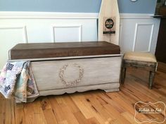 an old trunk is sitting on the floor in front of a chair and table with a blanket