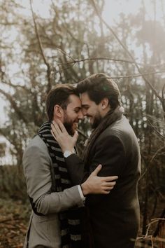 two men hugging each other in the woods